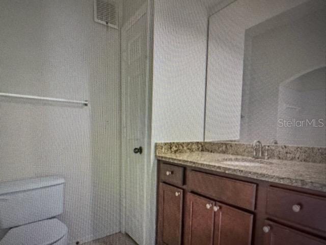 bathroom featuring toilet and vanity