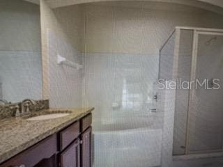 bathroom featuring a shower and vanity