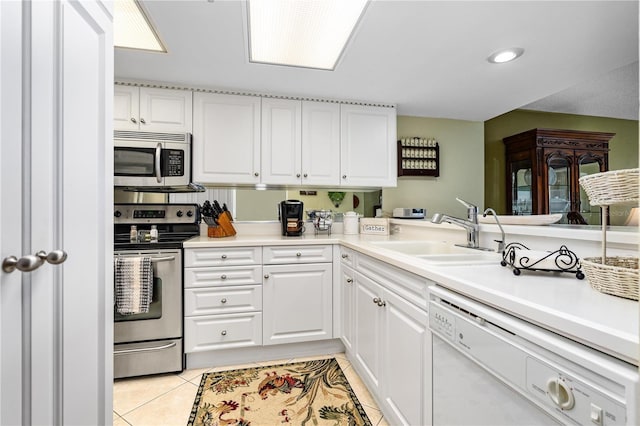 kitchen featuring sink, white cabinets, light tile patterned floors, and appliances with stainless steel finishes