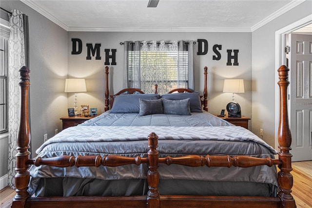 bedroom with ceiling fan, ornamental molding, and hardwood / wood-style floors