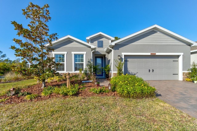 view of front of property featuring a garage and a front lawn