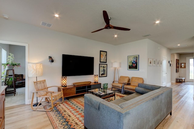 living room featuring light hardwood / wood-style flooring and ceiling fan