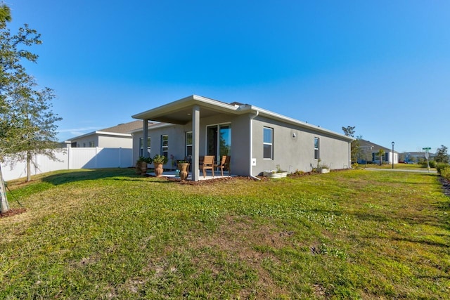 rear view of property featuring a yard and a patio