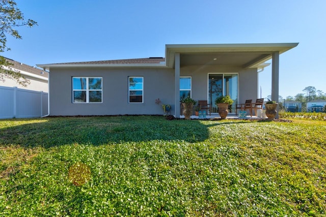 rear view of house featuring a yard