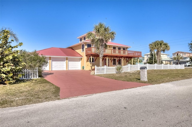 view of front of home with a balcony and a front lawn