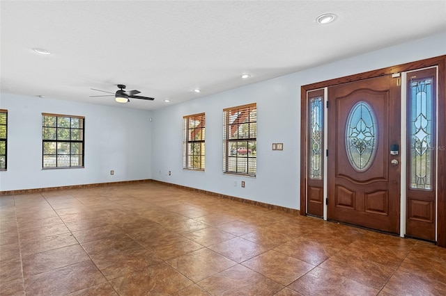 tiled foyer featuring ceiling fan