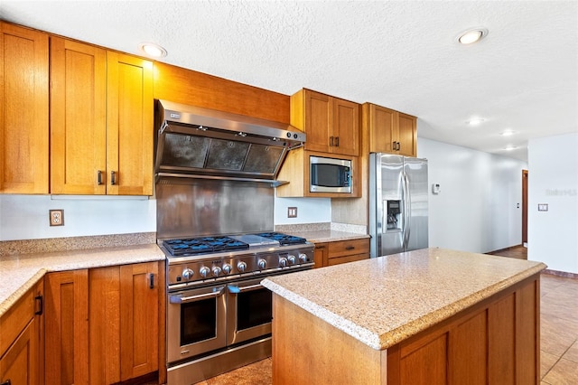 kitchen with stainless steel appliances, a center island, light tile patterned floors, light stone counters, and extractor fan