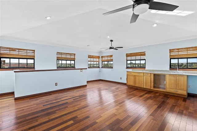 unfurnished living room featuring ceiling fan, dark wood-type flooring, and plenty of natural light