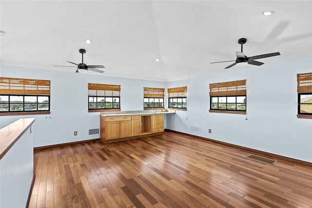 kitchen with vaulted ceiling, hardwood / wood-style floors, ceiling fan, and kitchen peninsula