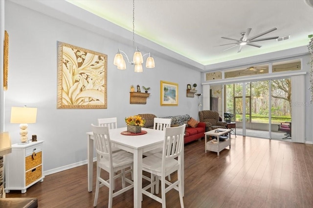 dining area featuring ceiling fan with notable chandelier and dark hardwood / wood-style floors