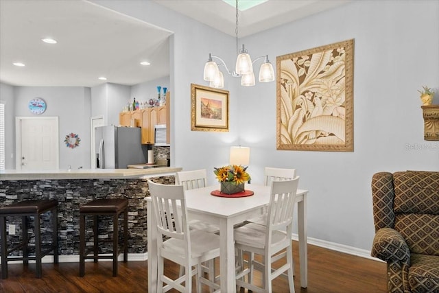 dining room featuring dark hardwood / wood-style flooring and an inviting chandelier