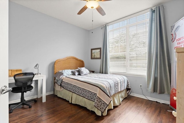 bedroom with ceiling fan, dark wood-type flooring, and multiple windows