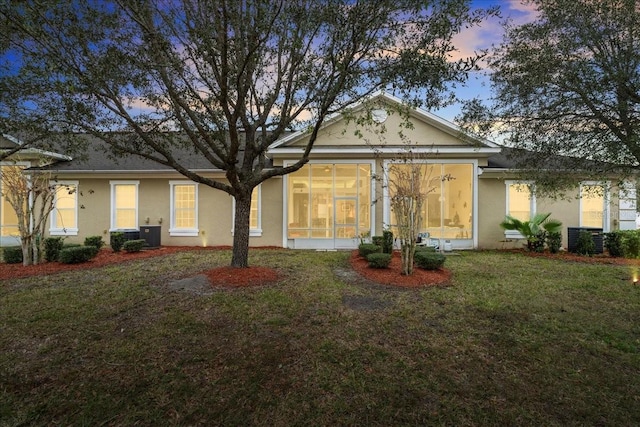 view of front facade featuring a lawn and cooling unit