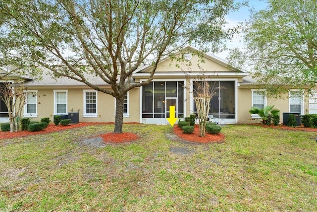 back of property featuring a sunroom, central AC unit, and a lawn