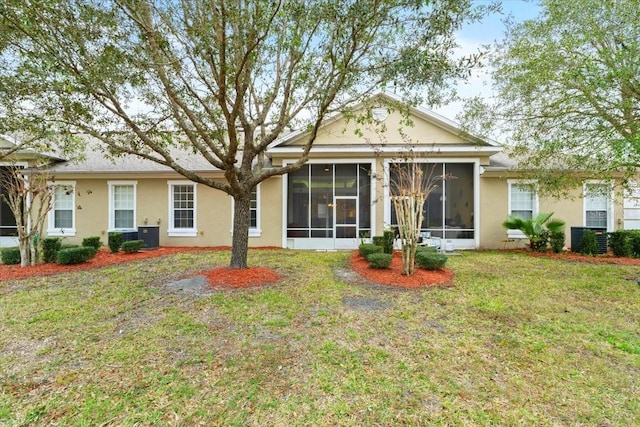 rear view of house featuring a yard, central AC, and a sunroom