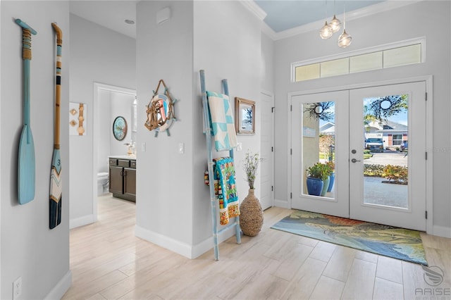 entryway featuring french doors, crown molding, and light hardwood / wood-style flooring