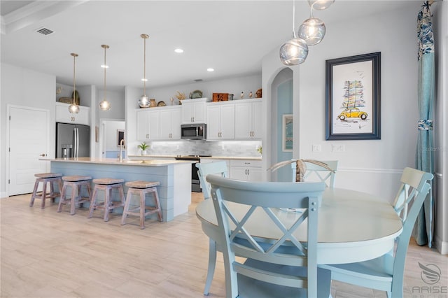 dining room featuring light wood-type flooring and sink