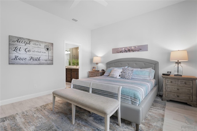 bedroom with ensuite bath, ceiling fan, and light hardwood / wood-style floors