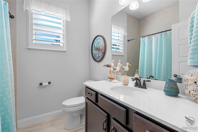 bathroom with wood-type flooring, a shower with curtain, vanity, and toilet