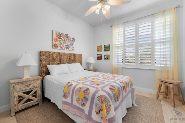 bedroom featuring ceiling fan, light wood-type flooring, and multiple windows