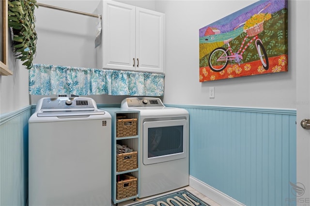 laundry room with washing machine and dryer and cabinets