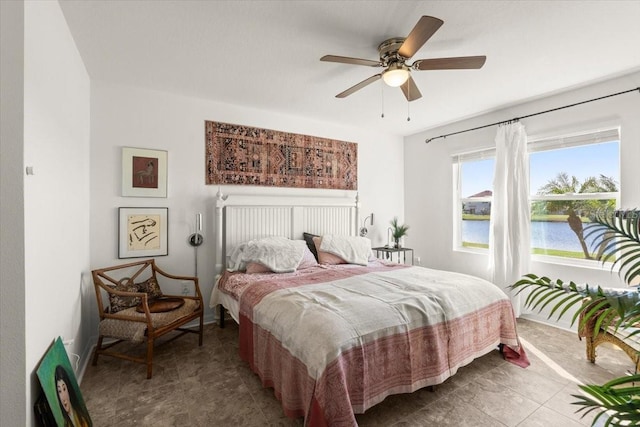 bedroom featuring a water view and ceiling fan