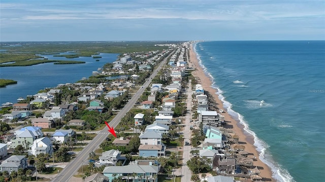 drone / aerial view featuring a water view and a view of the beach