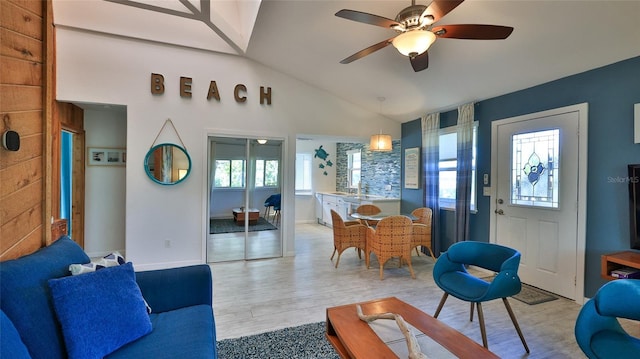 living room with ceiling fan, light hardwood / wood-style flooring, and lofted ceiling