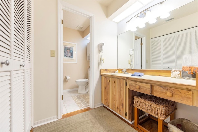 bathroom featuring tile patterned floors, vanity, and toilet