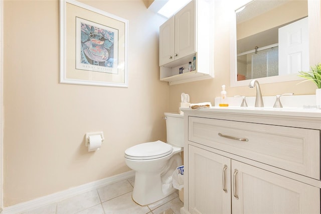 bathroom with toilet, vanity, and tile patterned floors