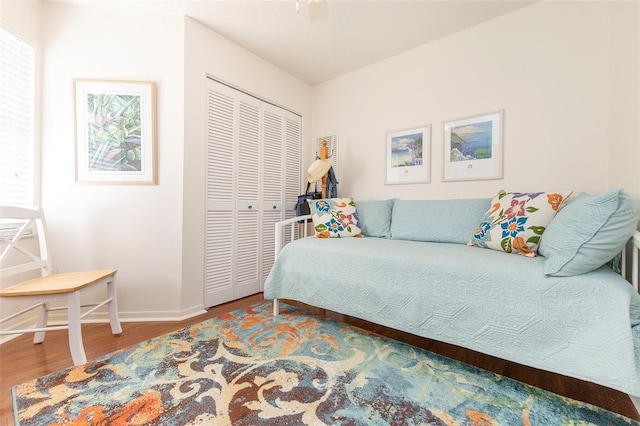 bedroom with hardwood / wood-style flooring, ceiling fan, and a closet