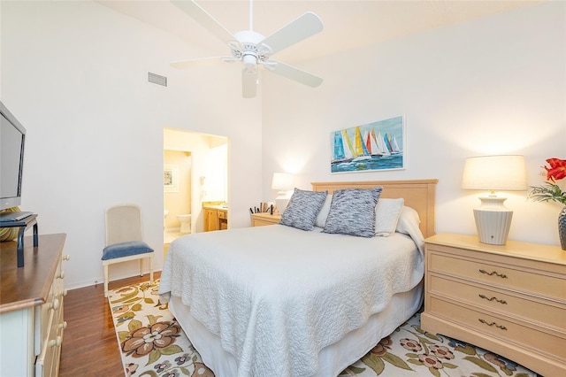 bedroom with ensuite bathroom, a high ceiling, ceiling fan, and dark wood-type flooring