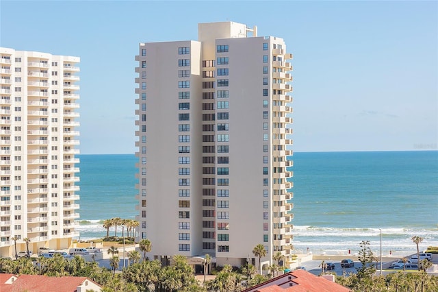 view of building exterior with a beach view and a water view