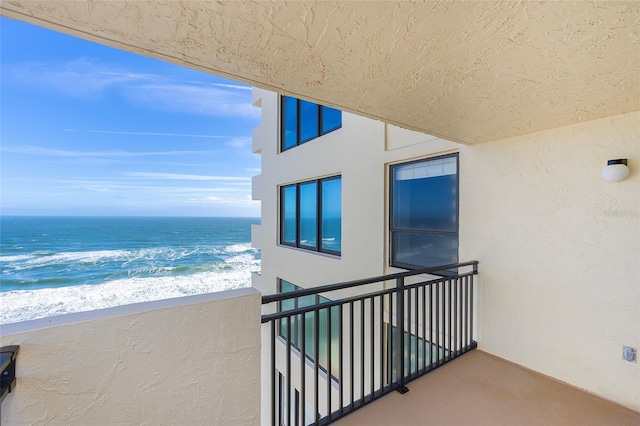 balcony featuring a beach view and a water view