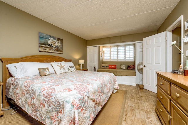 bedroom with a textured ceiling and light hardwood / wood-style flooring