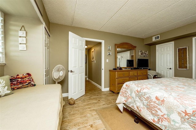 bedroom with light wood-type flooring and a closet