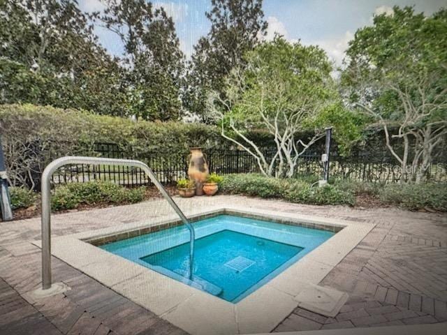 view of swimming pool featuring an in ground hot tub