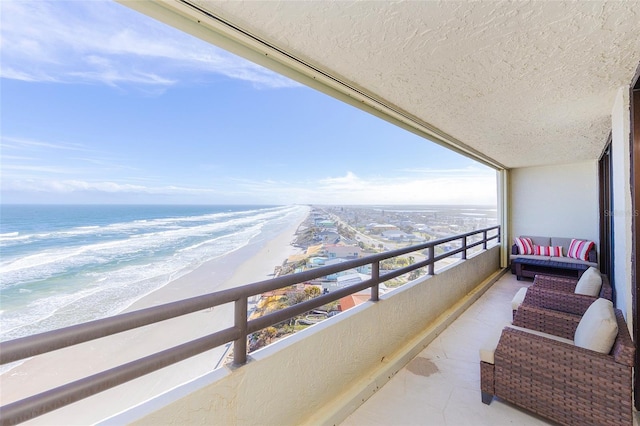 balcony featuring a beach view and a water view