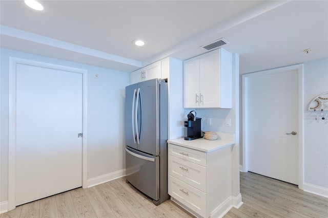 kitchen featuring white cabinetry, stainless steel refrigerator, and light wood-type flooring