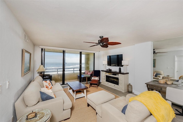 living room with ceiling fan and expansive windows