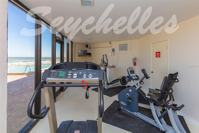 gym with a wall unit AC and a water view