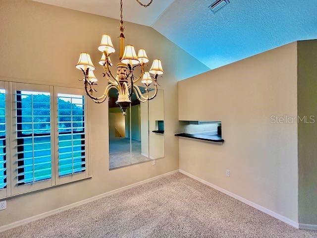 interior space featuring lofted ceiling and an inviting chandelier