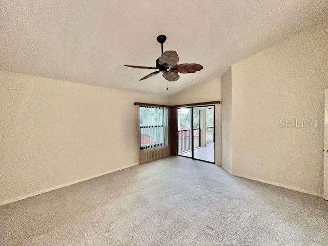 unfurnished room with ceiling fan, light colored carpet, a textured ceiling, and vaulted ceiling