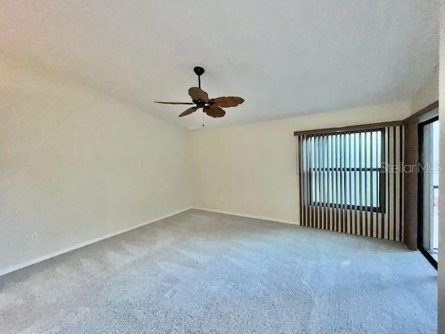 carpeted empty room featuring ceiling fan