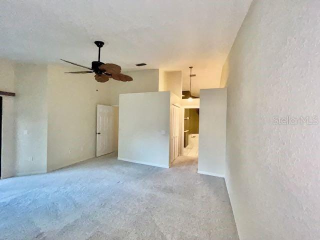 unfurnished living room featuring ceiling fan and light carpet