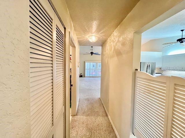 hallway with light colored carpet