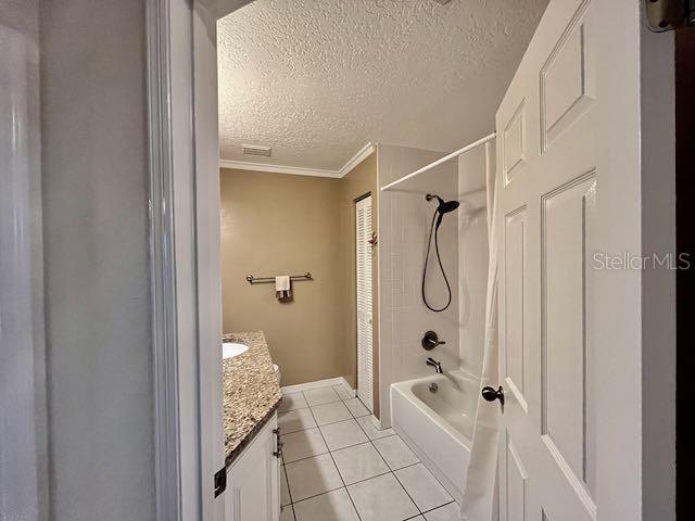 bathroom with shower / bath combination, tile patterned floors, a textured ceiling, ornamental molding, and vanity