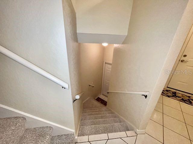 stairway with tile patterned floors