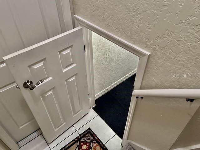 stairway with tile patterned floors