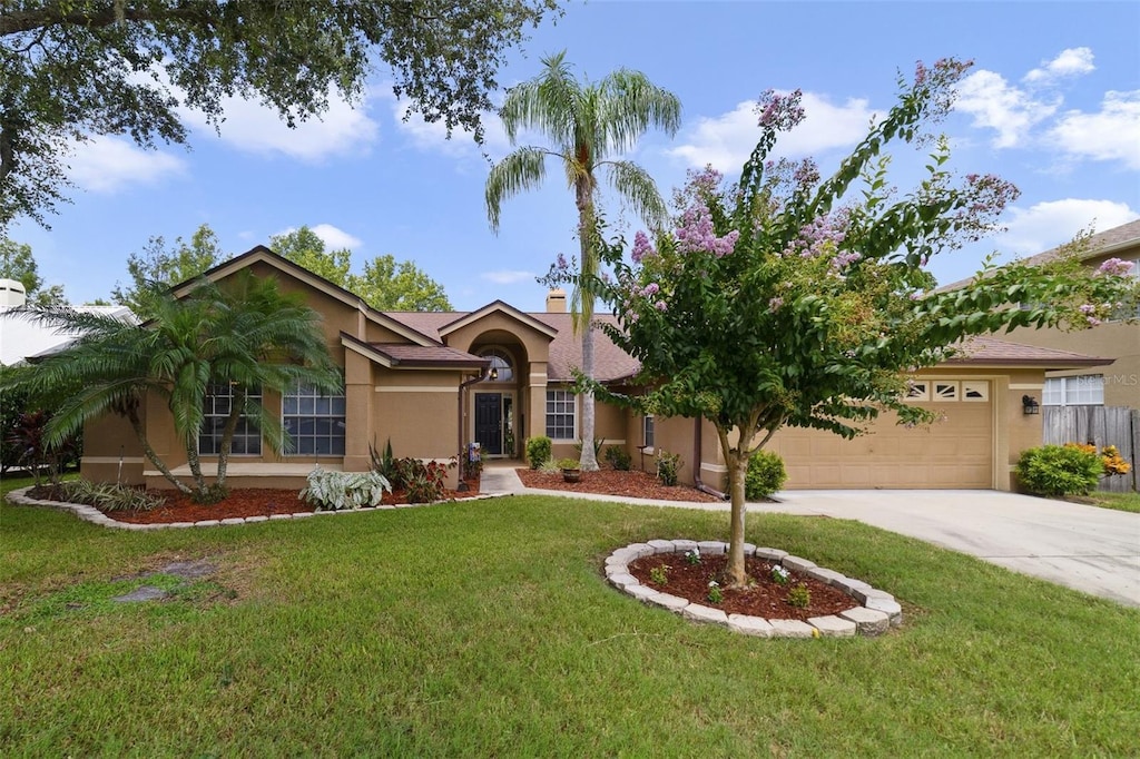 single story home featuring a front lawn and a garage